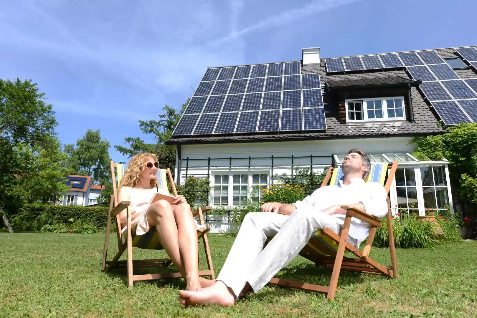 Homeowners relaxing outside a home with solar panels